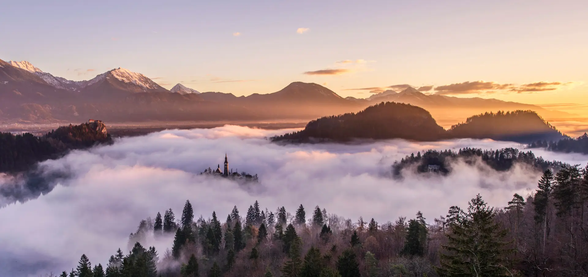 Mistična jutranja meglica nad gozdom in gorami retreata Lumorivellessia